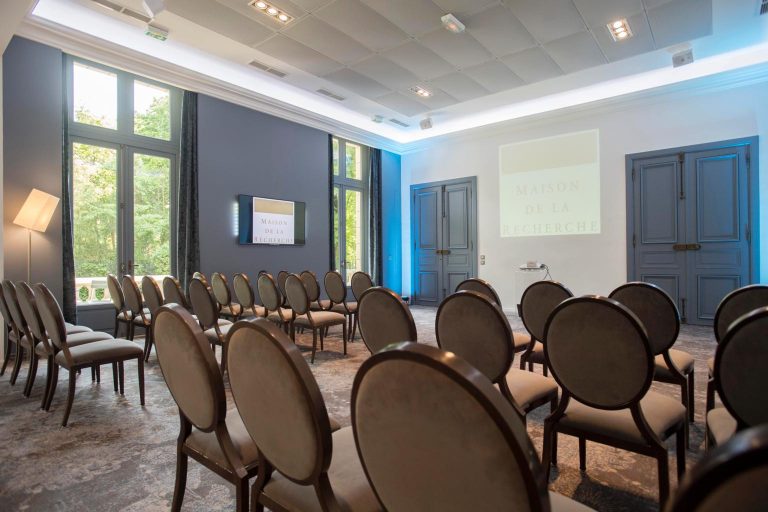 Salle de réunion lumineuse de l’hôtel particulier choisi pour la réunion des managers de KPMG, chaises en rangs face à l’écran