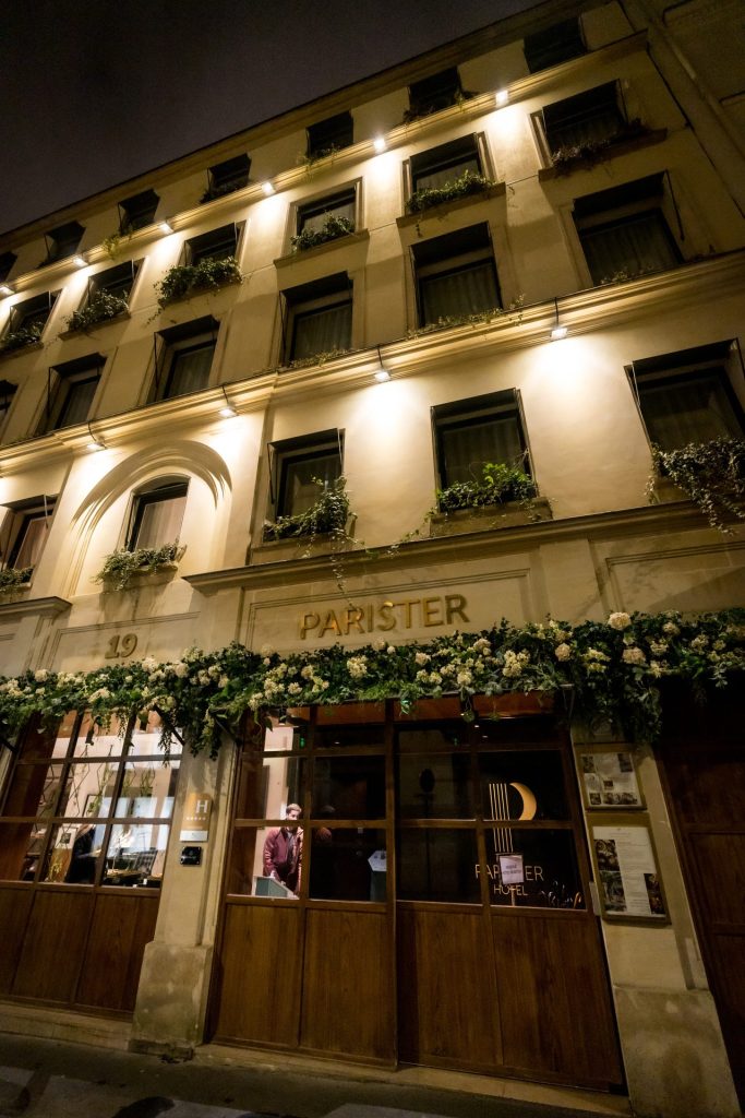 Entrée ornée d’une guirlande de fleurs blanches, de nuit, lieu de l’afterwork Deeplife organisé par Weevup à Paris 9e
