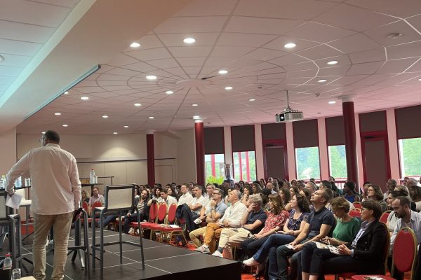 Plénière dans une grande salle avec un intervenant et des participants pour le séminaire Groupe Bancaire Ouest