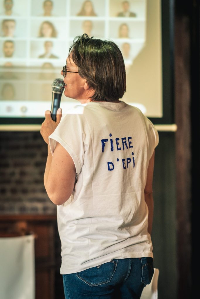Intervenante de dos, micro en main, en tee-shirt « Fière d’EPI » pendant la plénière du séminaire EPI 94