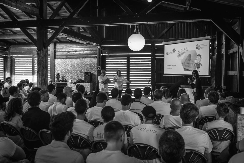 Plénière du séminaire EPI 94 dans une salle à charpente en bois, une intervenante au micro devant l’écran de présentation, séminaire organisé par Weevup