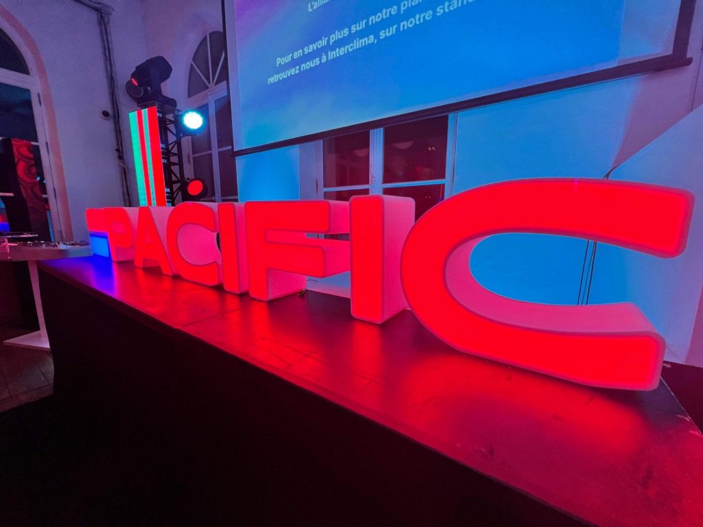 Lettres lumineuses rouges PACIFIC posées sur scène pour la soirée de lancement de marque du Groupe Atlantic