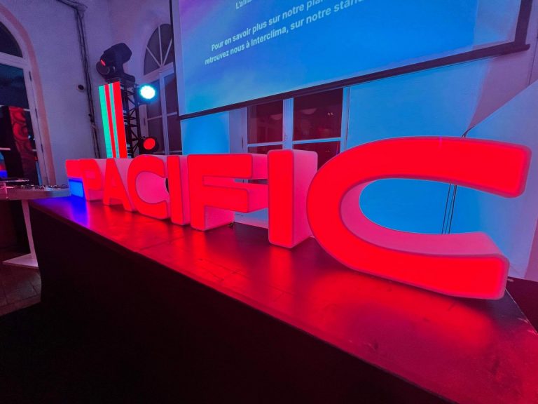 Lettres lumineuses rouges PACIFIC posées sur scène pour la soirée de lancement de marque du Groupe Atlantic