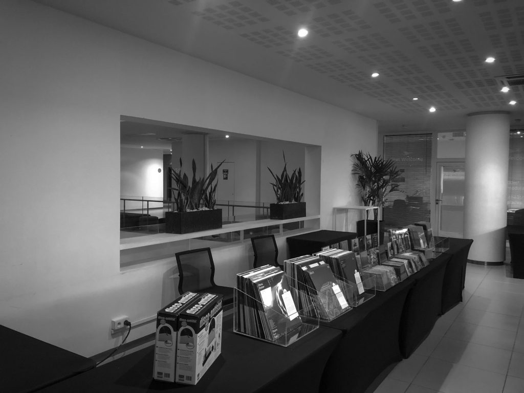 Tables d’exposition avec des bacs de disques vinyles dans un espace du salon Publison, au Novotel Paris Est