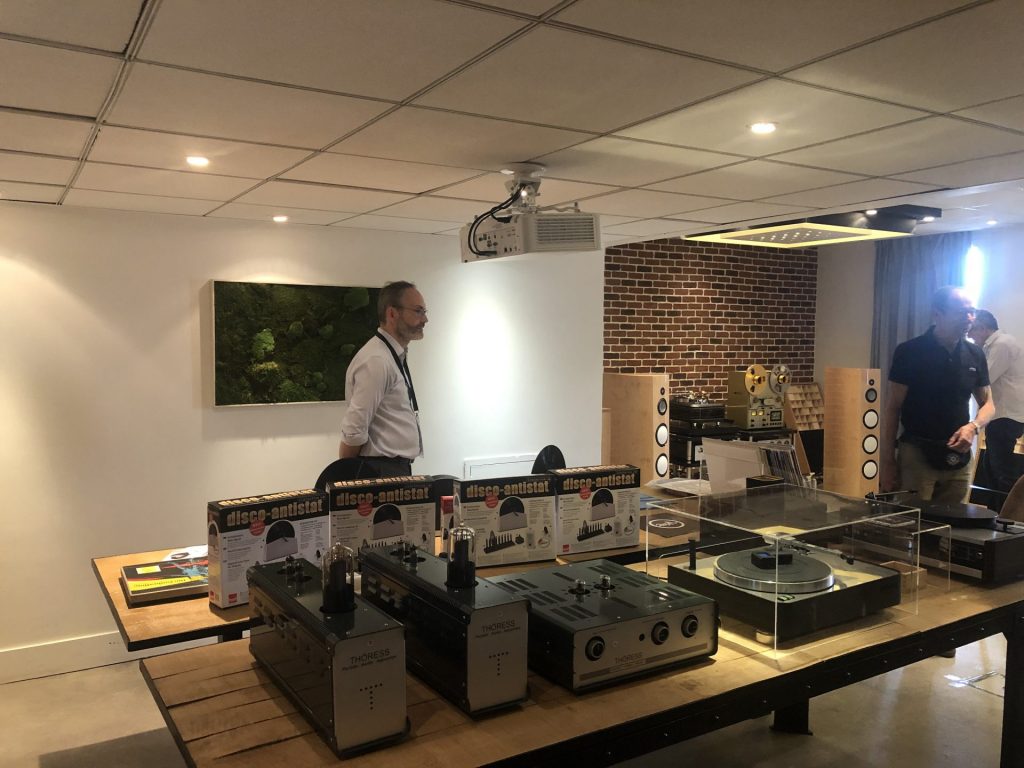 Stand d’exposant au salon Publison, avec amplificateurs à lampes et platine vinyle présentés sur une table, au Novotel Paris Est