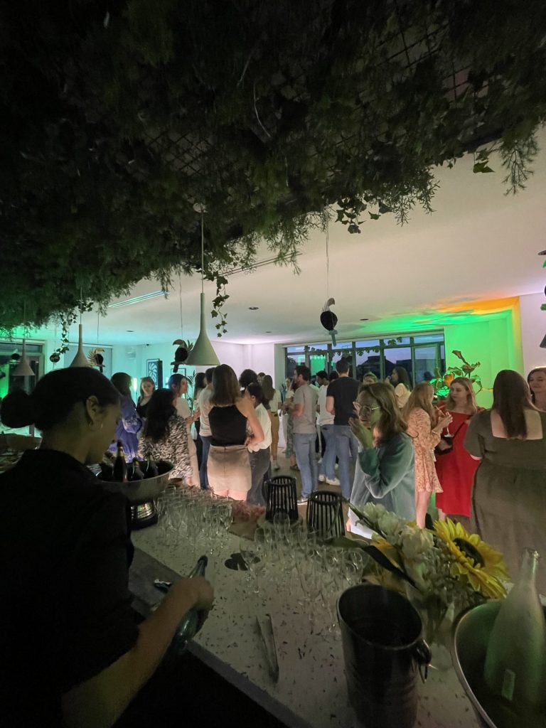 Bar garni de flûtes et de tournesols, avec les invités de la summer party Havea Group en arrière-plan, afterwork organisé par Weevup