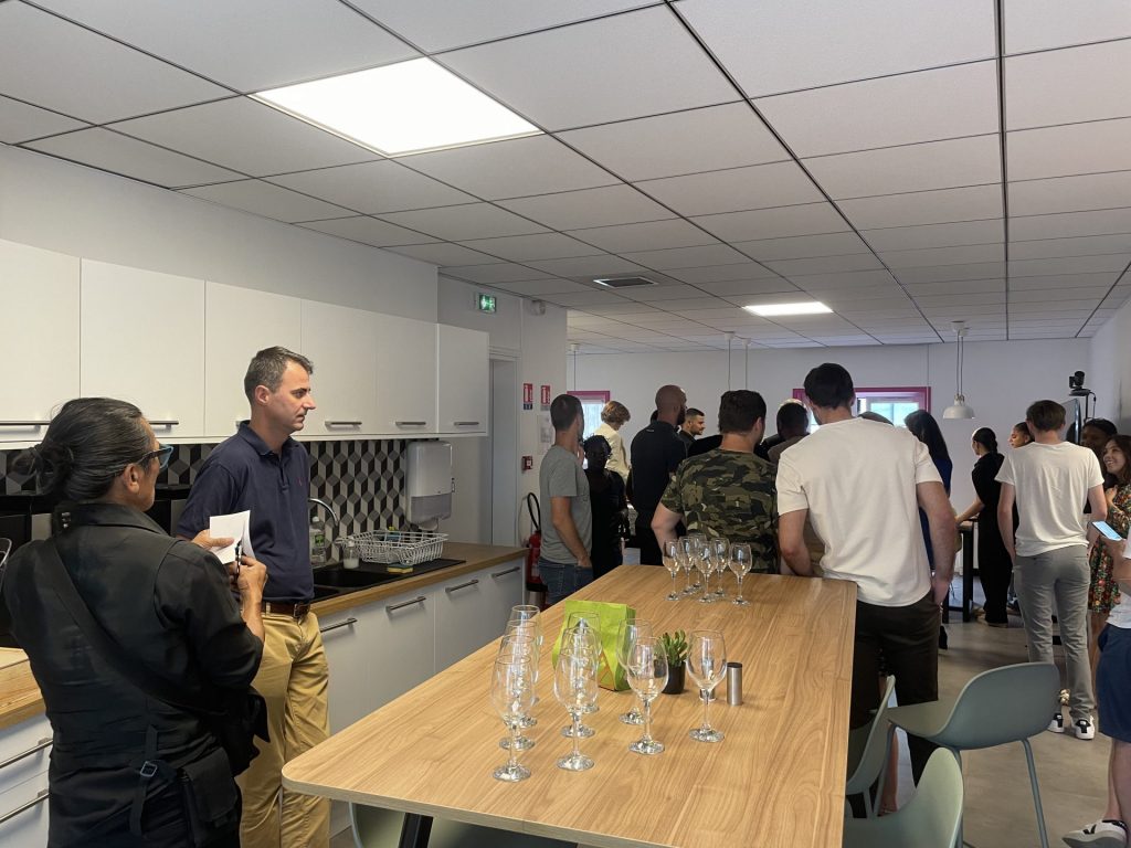 Invités de l’afterwork Ouicar rassemblés près d’une table dressée de verres à pied, soirée organisée par Weevup