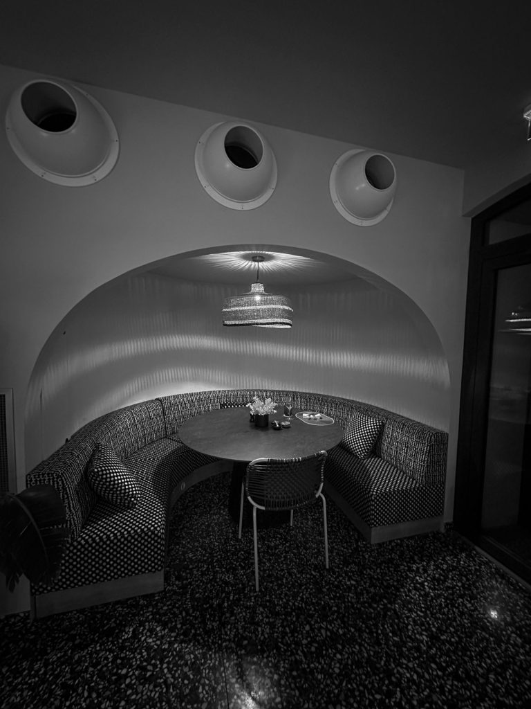 Alcôve avec banquette arrondie autour d’une table ronde, en noir et blanc, pendant le séminaire Husqvarna à Biarritz organisé par Weevup