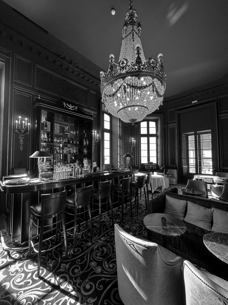 Salon-bar sous un lustre en cristal, en noir et blanc, dans l’hôtel privatisé pour le séminaire résidentiel Husqvarna à Biarritz