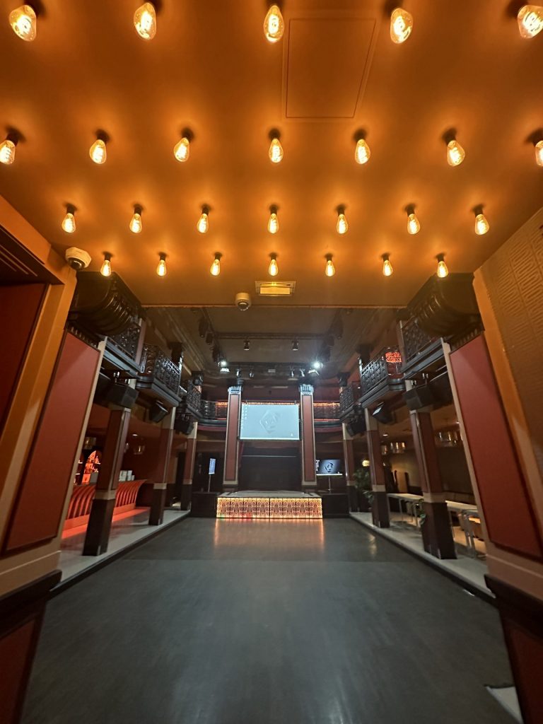 Grande salle de l’ancienne banque avant la soirée awards Scalian, avec son plafond d’ampoules, ses balcons en fer forgé et sa scène éclairée