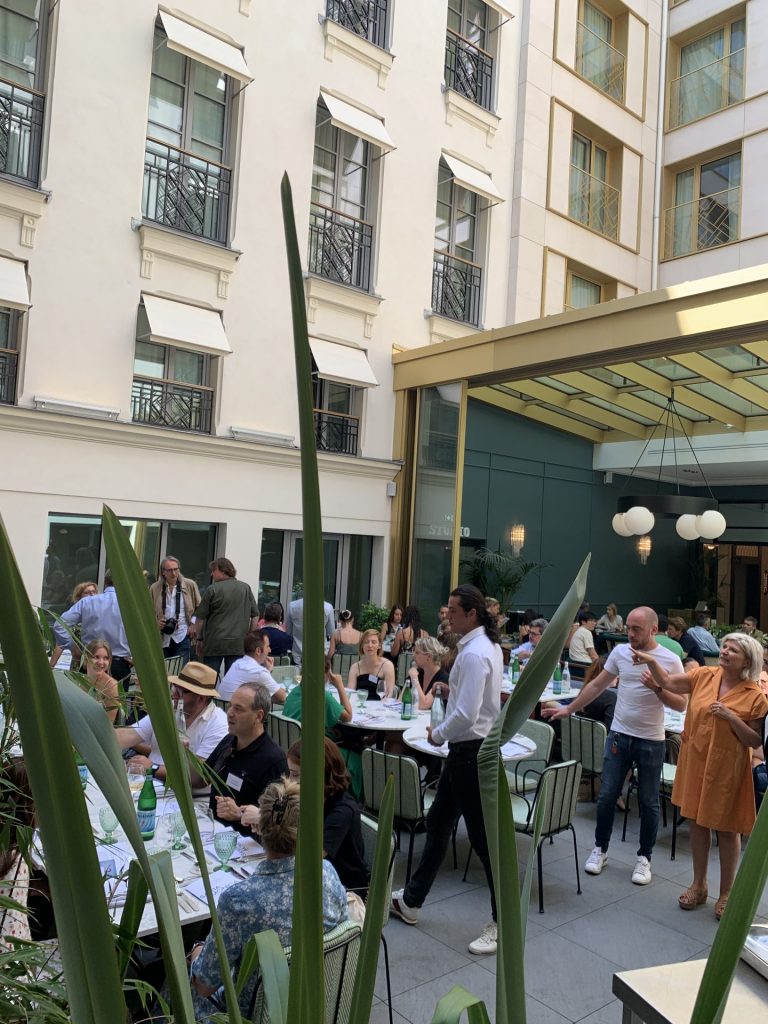 Participants attablés et debout dans le patio de l’hôtel Kimpton, pendant la soirée team building organisée par Weevup