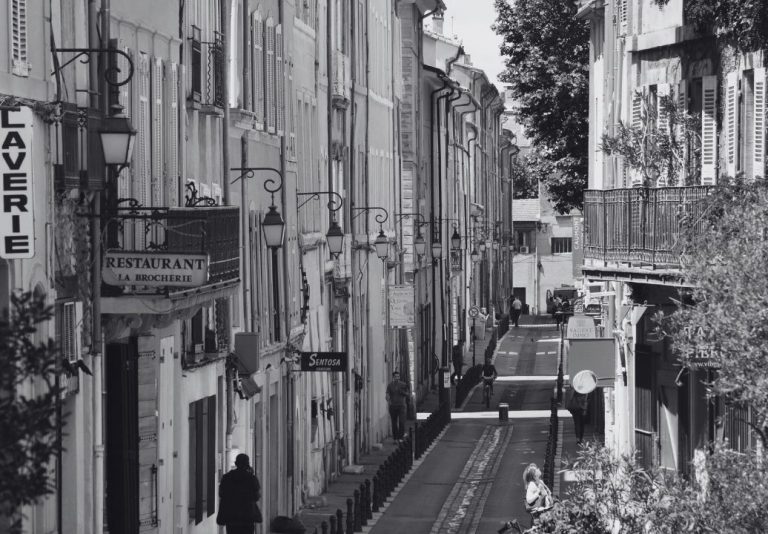 La rue Fernand Dol, dans le centre d’Aix-en-Provence, avec ses façades anciennes, ses lanternes et ses restaurants, en noir et blanc