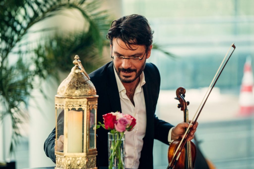 Violoniste derrière une lanterne dorée et un bouquet de roses, décor oriental de la soirée Interface organisée par Weevup