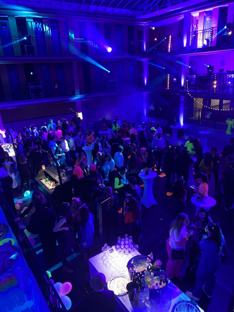Guests in neon lighting seen from the Molitor galleries, at Havea Group’s neon end-of-year party