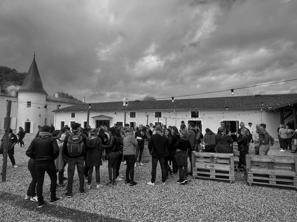 Groupe de participants du team building Cerfrance dans la cour du lieu, photo en noir et blanc, Weevup