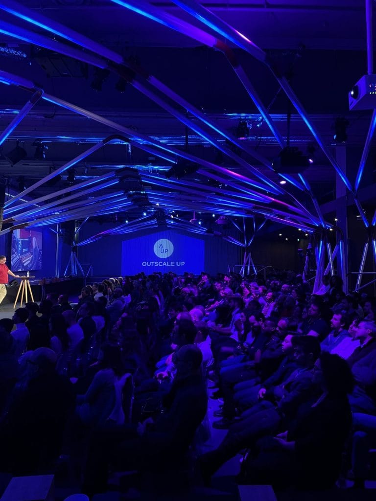 Participants at 3DS Outscale’s annual conference facing the screen, under the light tubes of the T7