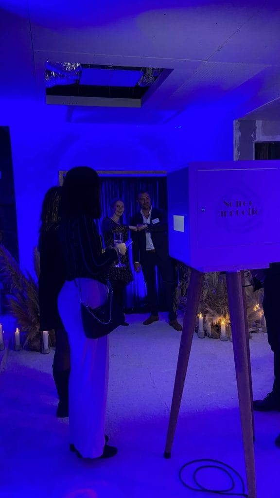 Invités réunis dans une salle baignée de lumière bleue, lors de la cocktail party Delpha organisée par Weevup