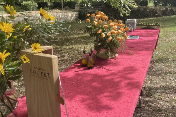 photo en exterieur d'une table rouge decorées de fleurs à l'occasion du séminaire pour l'université de Bordeaux