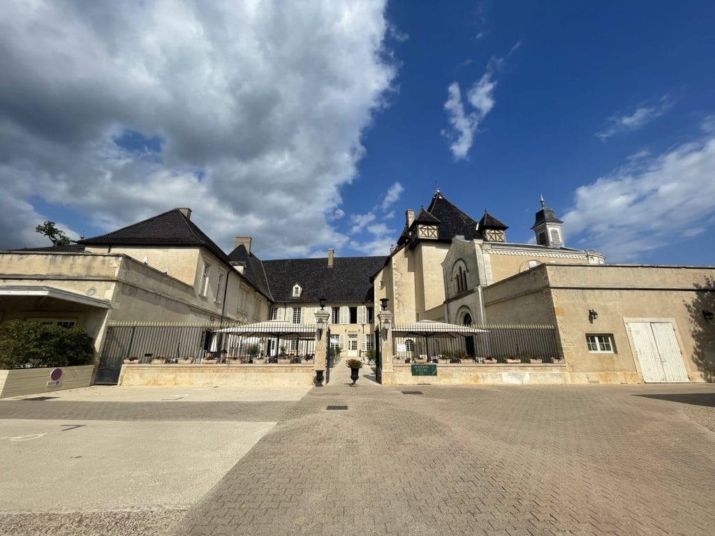 Façade et cour pavée du Château de Pizay sous un ciel bleu, lieu du séminaire Pacific et Général organisé par Weevup