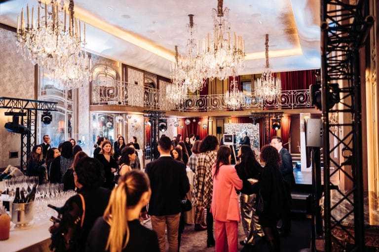 Invités de la soirée de lancement de produit de Vanessa Wu réunis dans un salon aux lustres en cristal