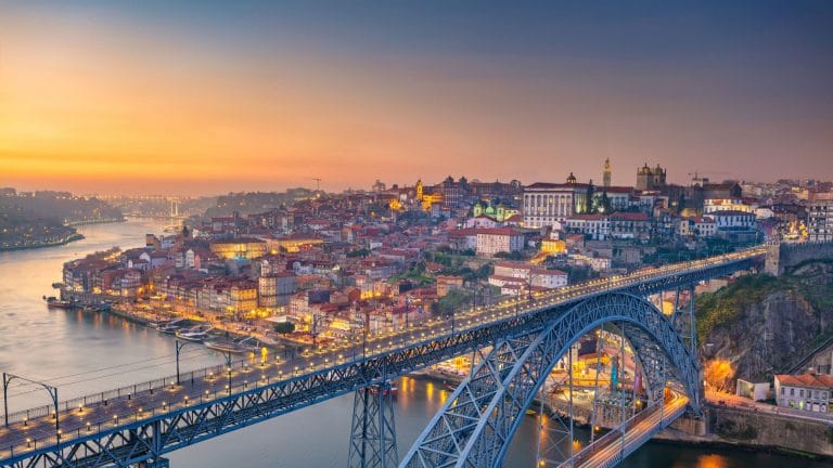 Porto au coucher du soleil, avec le pont Dom Luís I enjambant le Douro et la vieille ville illuminée
