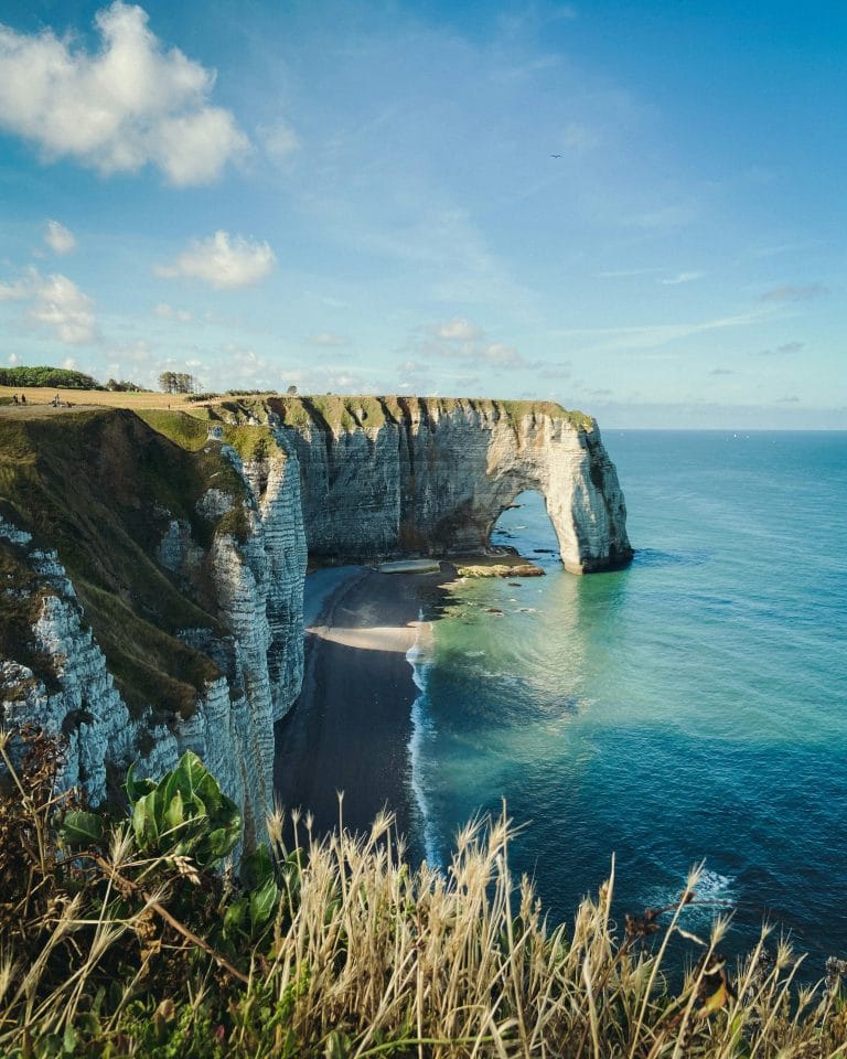 Arche de craie au-dessus d’une mer turquoise, vue depuis le sentier des falaises d’Étretat