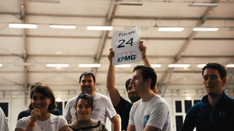 Membre d’une équipe brandissant le panneau « Équipe 24 » pendant les olympiades du séminaire KPMG
