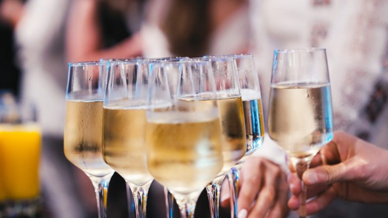 Invités trinquant avec des verres de vin blanc pétillant lors du buffet du séminaire KPMG