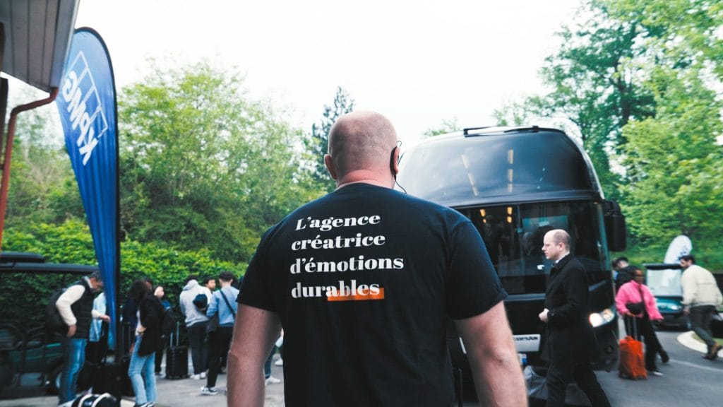Un membre de l’équipe Weevup devant une navette et des participants du séminaire KPMG avec leurs valises