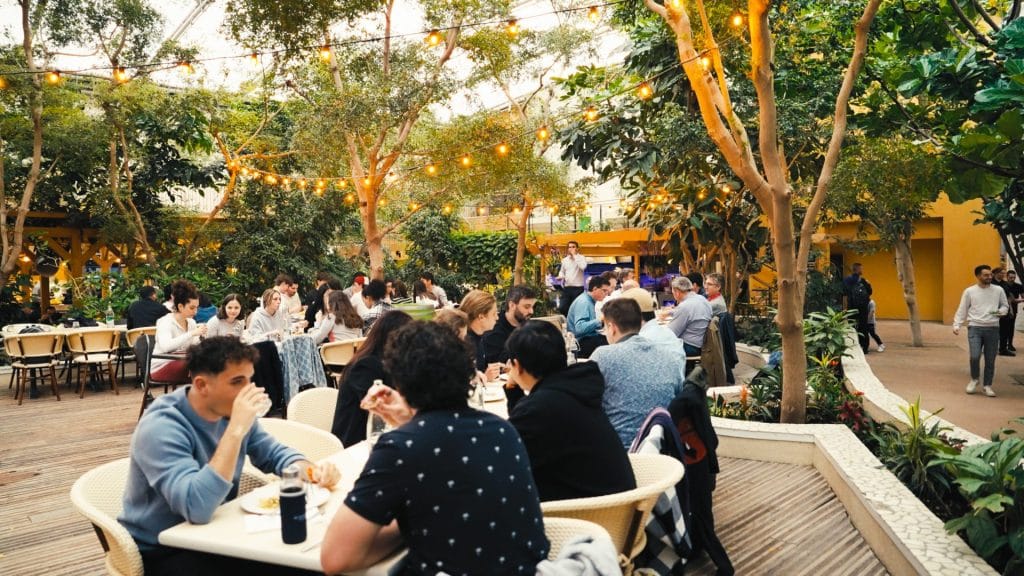 Collaborateurs attablés au milieu de la végétation pendant un repas du séminaire de 900 participants de KPMG, au Center Parcs du Lac d’Ailette