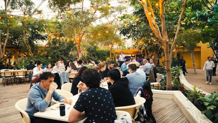 Participants du séminaire KPMG attablés en terrasse parmi les arbres, pendant le buffet en extérieur au Center Parcs du Lac d’Ailette