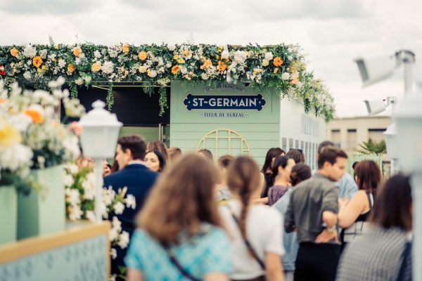 photo de l'entrée de la cocktail party dior avec une cabane verte fleurie