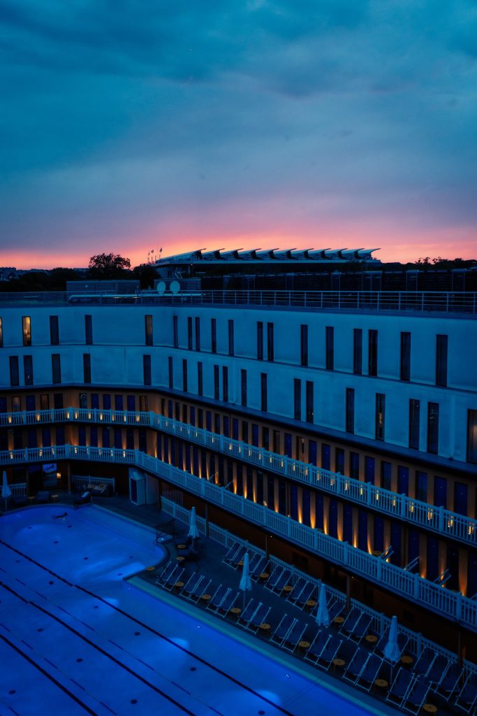 Coucher de soleil sur une piscine et ses façades, vue pendant la cocktail party Dior organisée par Weevup