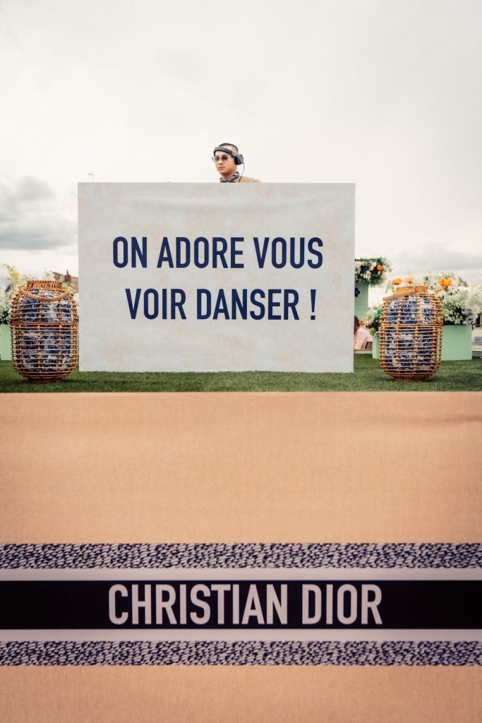 Panneau invitant à danser devant la cabine du DJ, décor aux couleurs de Christian Dior, pendant la cocktail party Dior organisée par Weevup