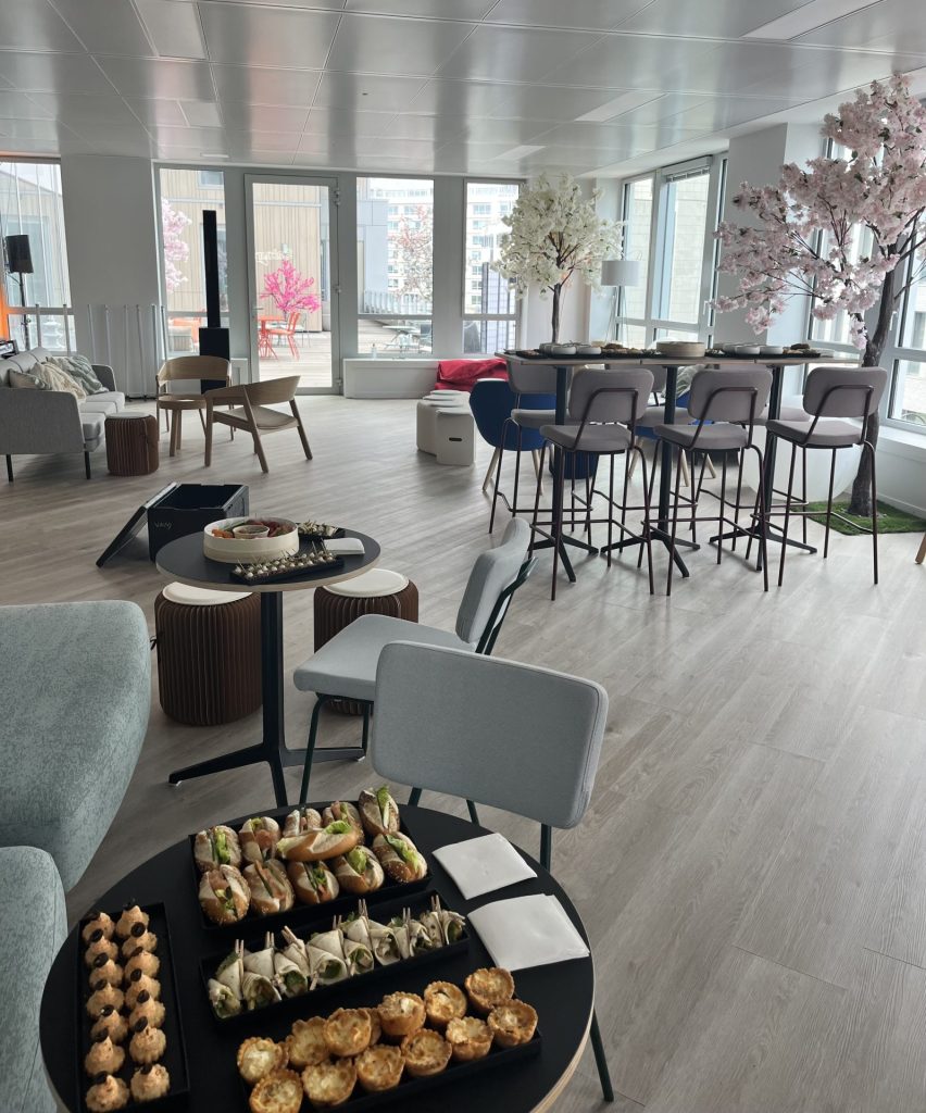 Plateaux de bouchées et espace aménagé avec tables hautes et cerisiers en fleurs, pour l’inauguration des nouveaux bureaux de Daiichi organisée par Weevup