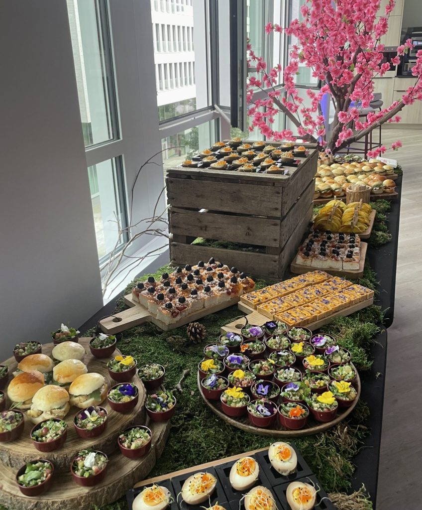 Buffet de pièces cocktail dressé sur un lit de mousse, devant une baie vitrée, pendant l’inauguration des bureaux de Daiichi organisée par Weevup