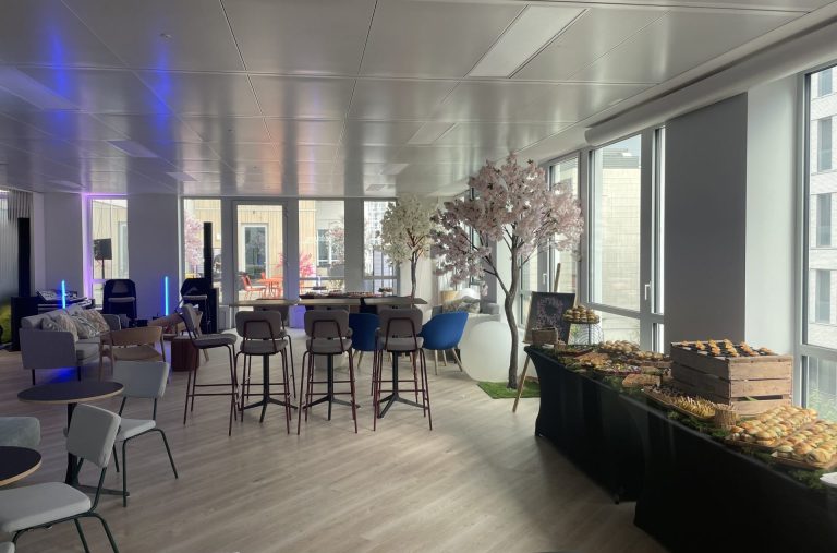 Salle des nouveaux locaux de Daiichi préparée pour l’inauguration organisée par Weevup : cerisiers en fleurs, tables hautes et buffet devant de grandes baies vitrées