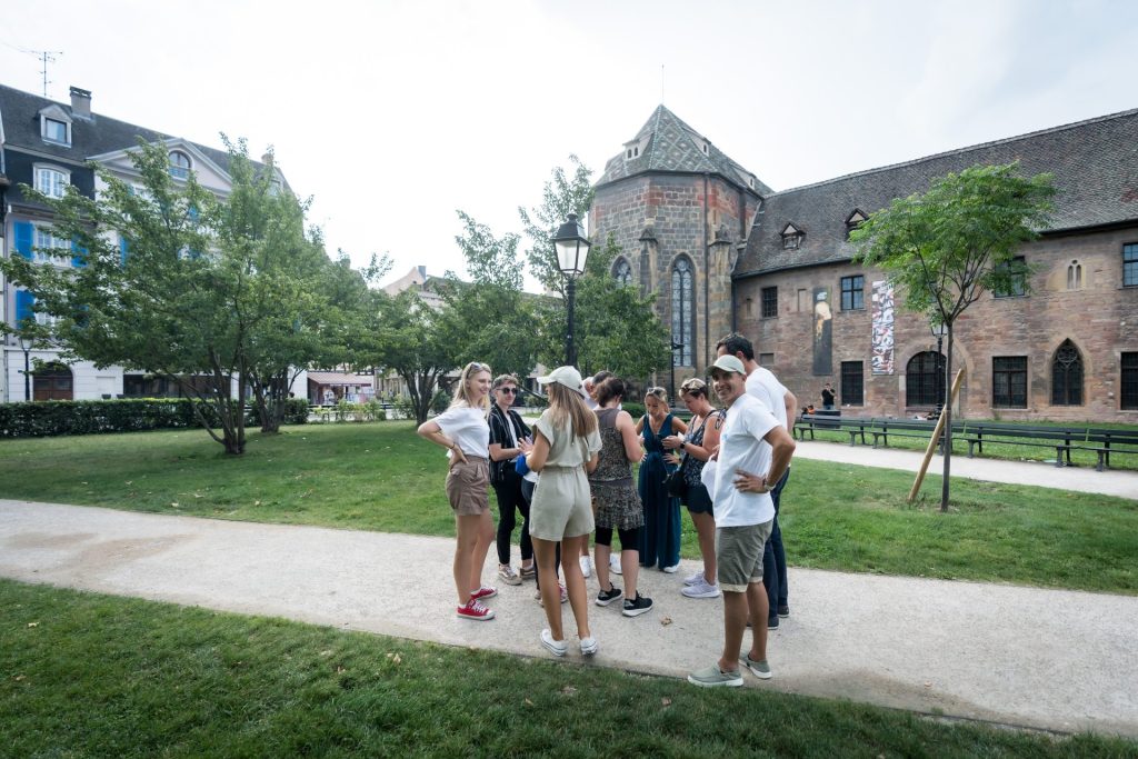 Petit groupe de collaborateurs d’Elanco réunis sur une allée de jardin devant un bâtiment ancien en pierre, pendant leur séminaire en Alsace