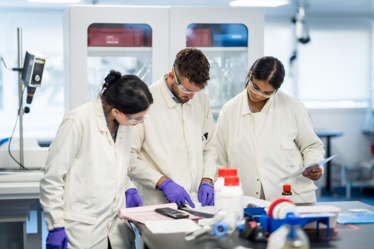 Collaborateurs d’Elanco en blouse blanche, lunettes et gants, dans un laboratoire du site de production de Huningue, pendant la visite du séminaire
