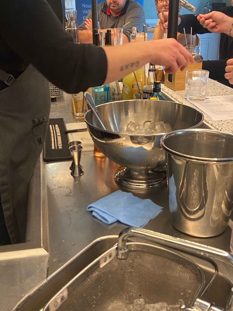 Un barman prépare un cocktail devant les participants pendant l’activité mixologie de la journée d’étude Produal organisée par Weevup