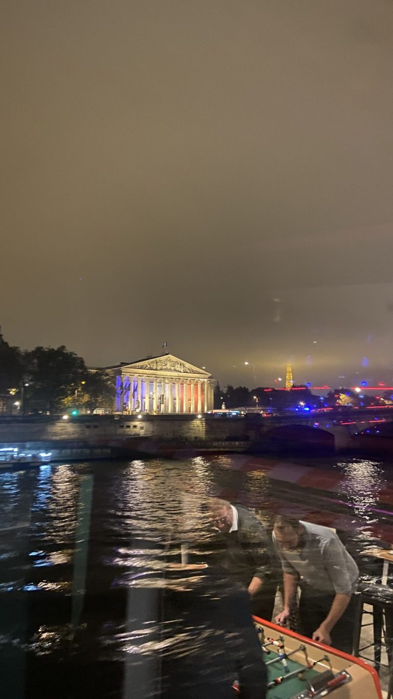 Night view of the Seine from the River’s King, with an illuminated colonnaded building on the bank, during Hanwha’s post-show evening