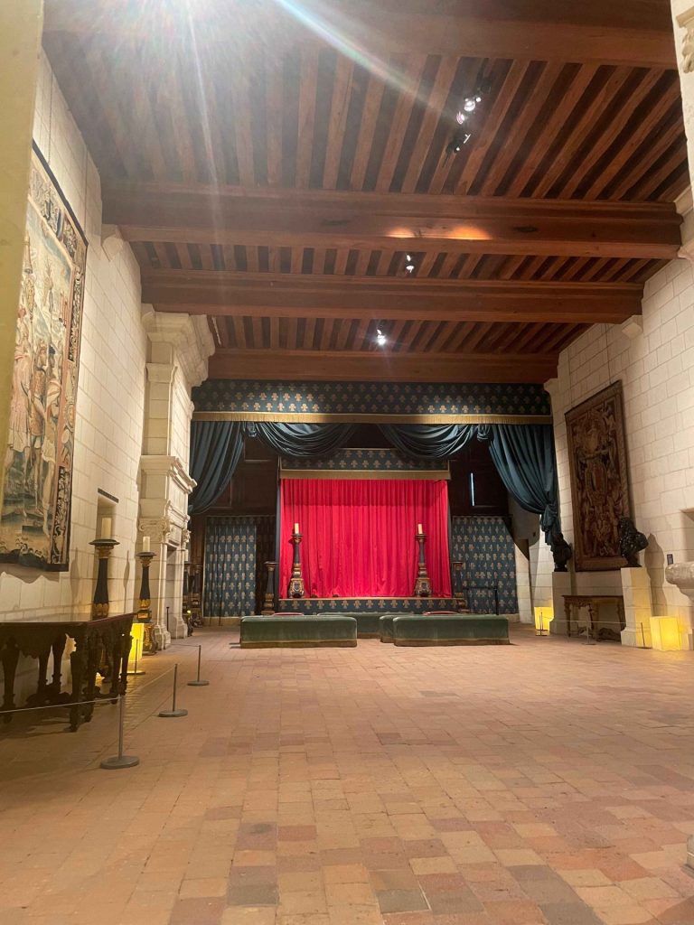 Grande salle ornée de tapisseries, avec une scène à rideau rouge, visitée au château de Chambord pendant le séminaire des dirigeants de Generali