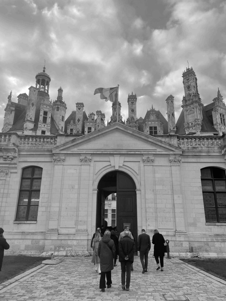 Participants du séminaire des dirigeants de Generali se dirigeant vers l’entrée du château de Chambord, photo en noir et blanc