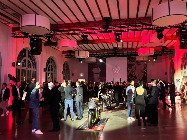 Invités de la soirée de passation Cofinas sous un éclairage rouge, à l’Orangerie d’Auteuil