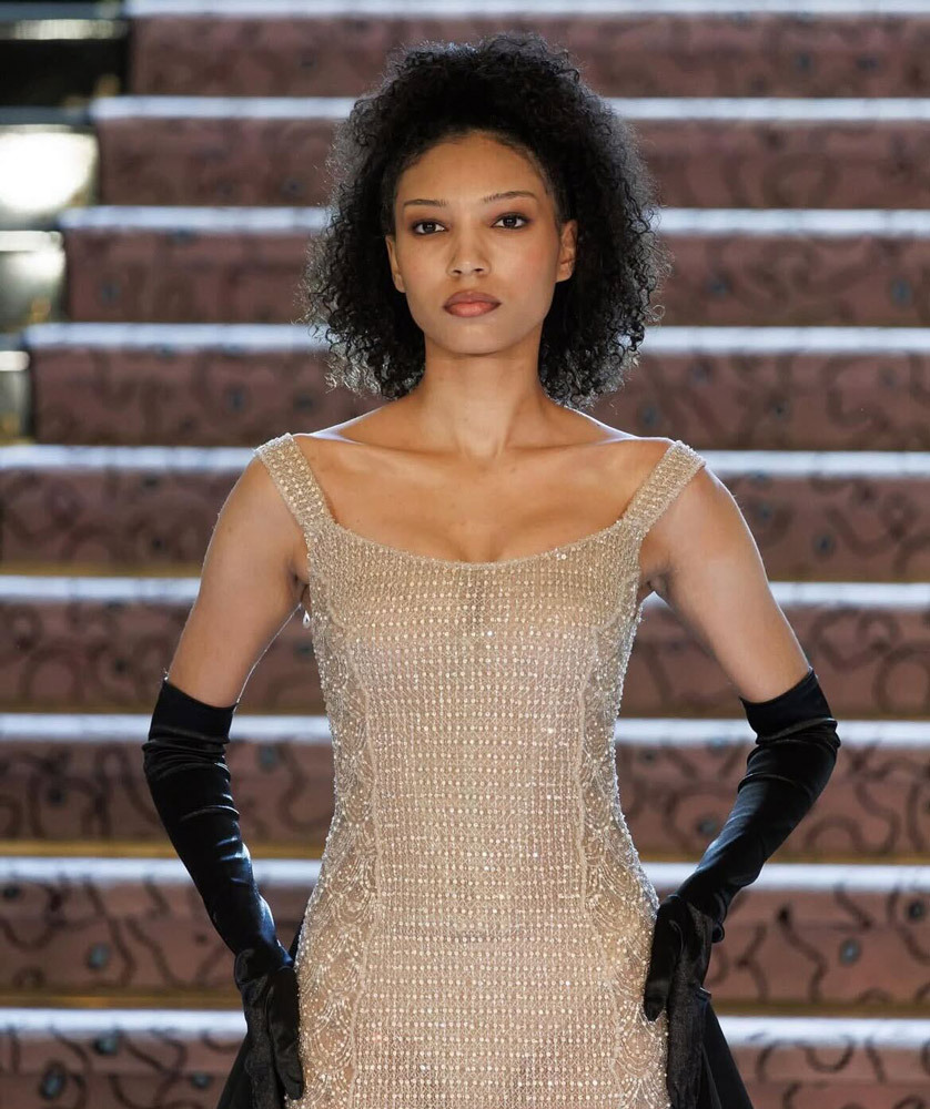 Mannequin en robe perlée champagne et longs gants noirs lors du défilé Fall-Winter 2025 de Yara Shoemaker à Paris
