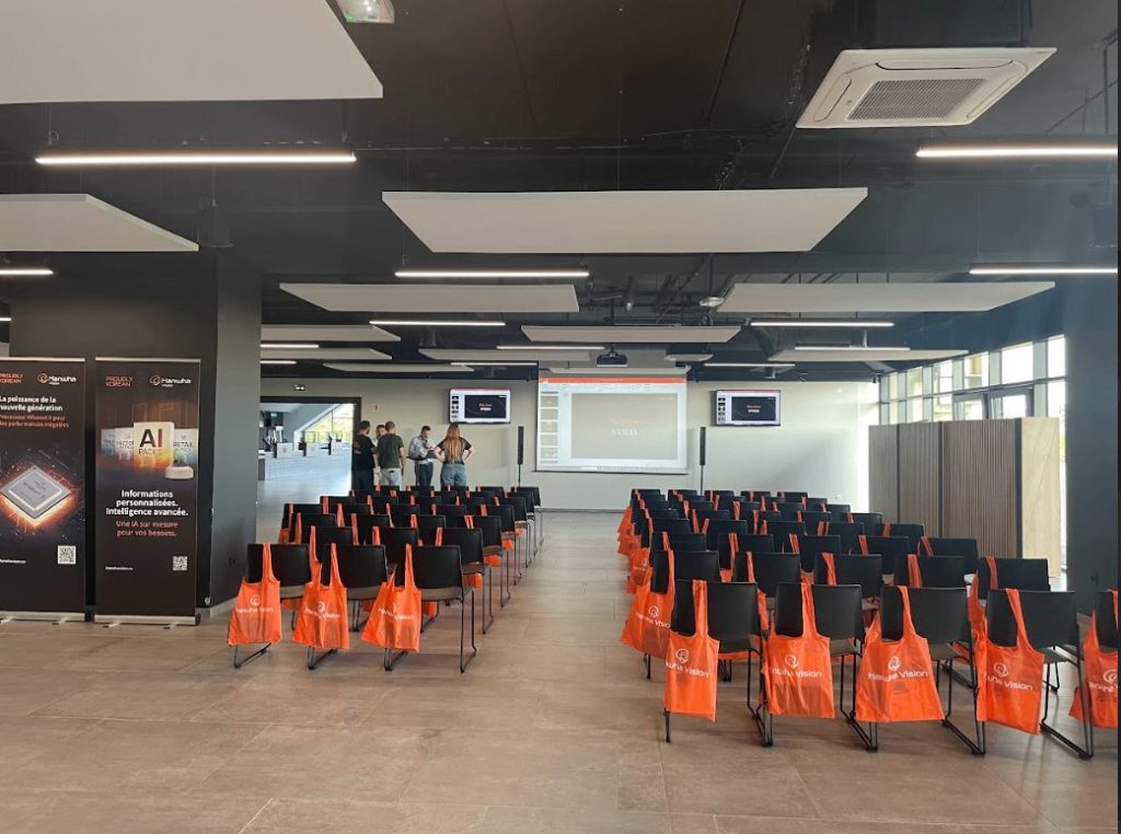 Salle de présentation du roadshow Hanwha avec chaises alignées et sacs orange posés sur les sièges, avant l’arrivée des participants, organisée par Weevup
