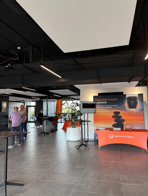 Stand Hanwha Vision avec visuel de communication et accueil des visiteurs pendant le Roadshow 2025 à Agen.