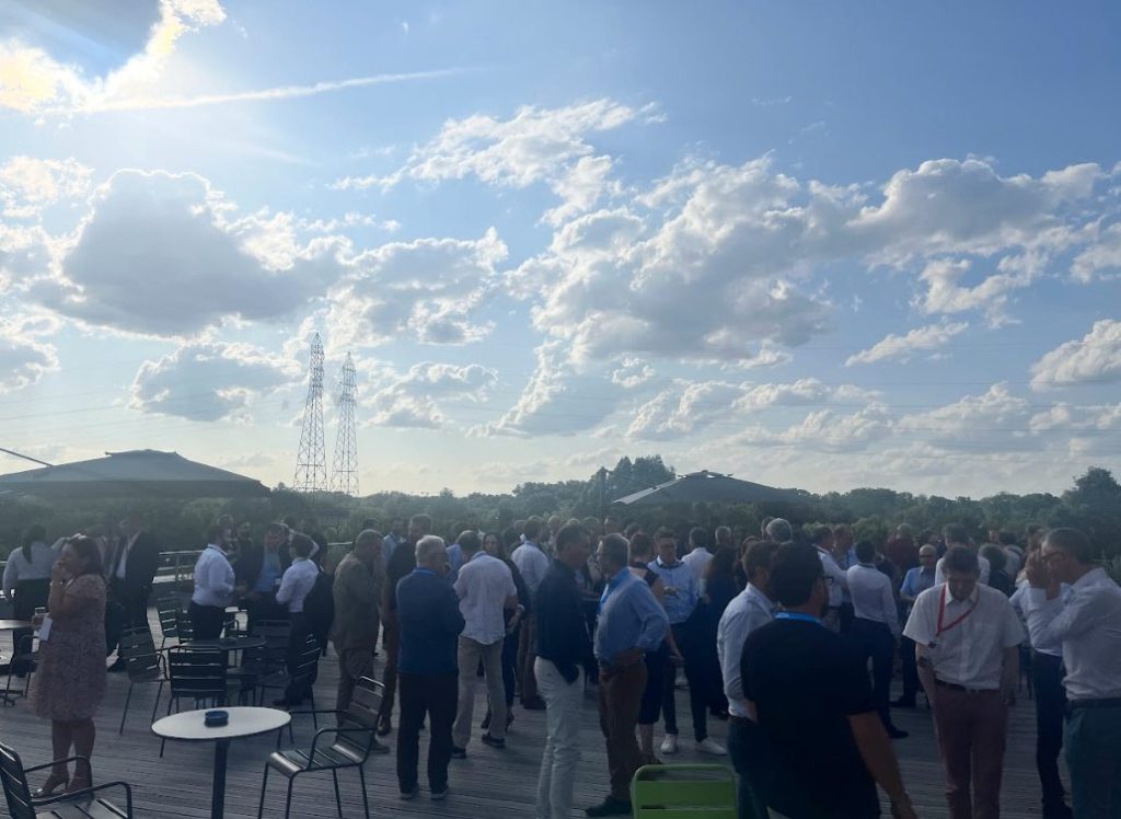Participants de SBS Connect Paris réunis debout sur une terrasse en plein air sous un ciel bleu, événement accompagné par Weevup aux portes de Paris