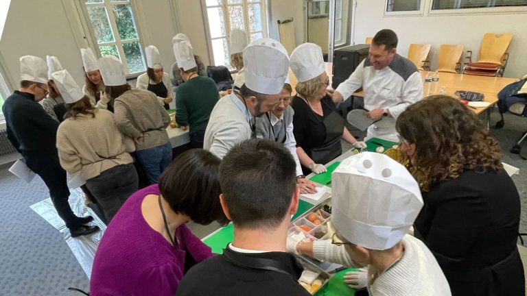 Collaborateurs de Bio-Rad en toques autour de planches à découper, pendant le challenge culinaire organisé dans leurs locaux