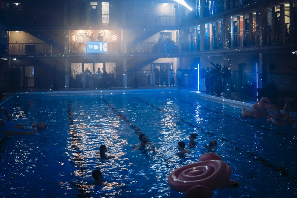 Baigneurs dans le bassin du Molitor éclairé en bleu, pendant la pool party des 10 ans de Weevup